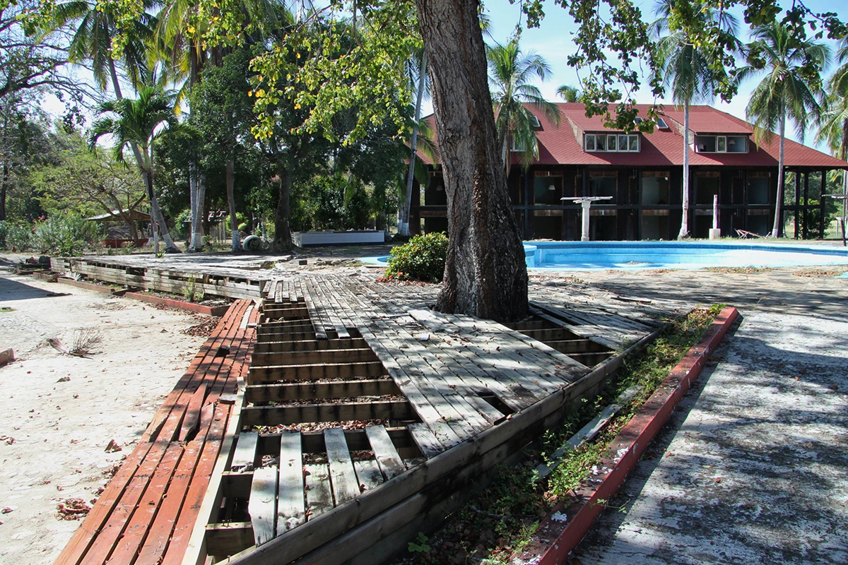 The resort grounds looking toward a pool and guest rooms. Much of the wooden walk-way planks had been looted.