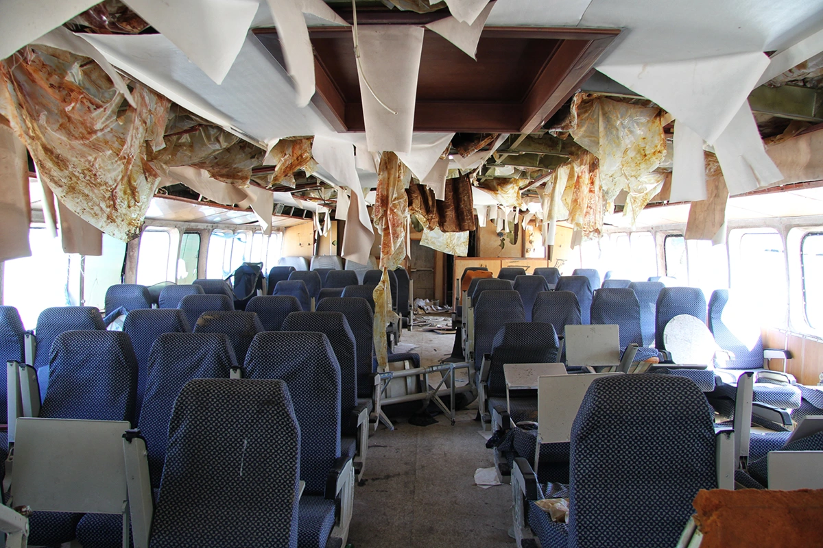 The passenger area of the Las Perlas 7. Most seat backs were forcibly removed. Weather battered ceiling material dangles from above.